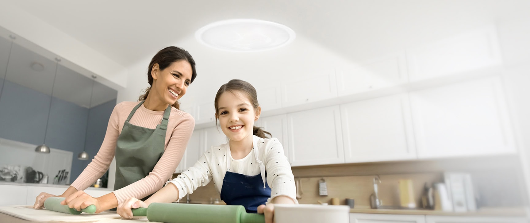 Mother and daughter in the kitchen underneath a tubular skylight